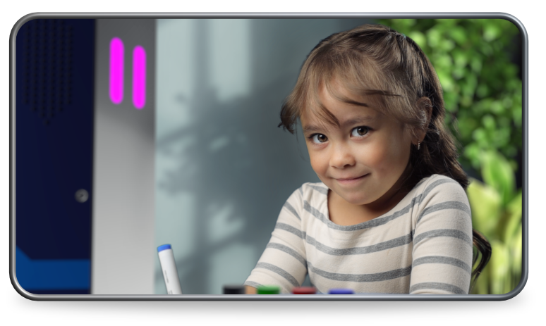 Student working at a learning station, smiling at camera